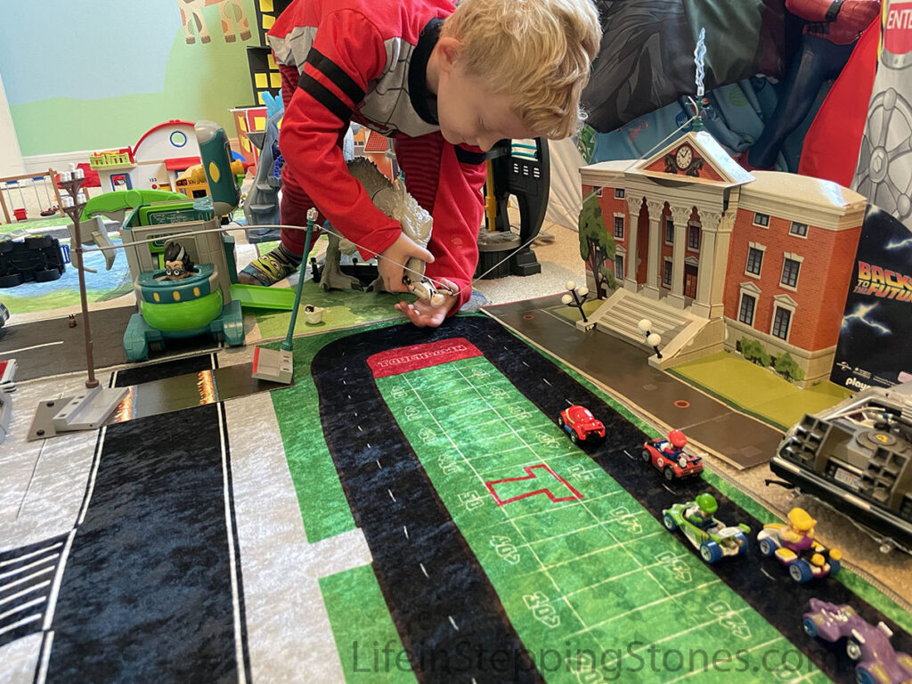 City theme toy rug for kid's bedroom or playroom features wide roads for larger toy cars and a hot wheels race track