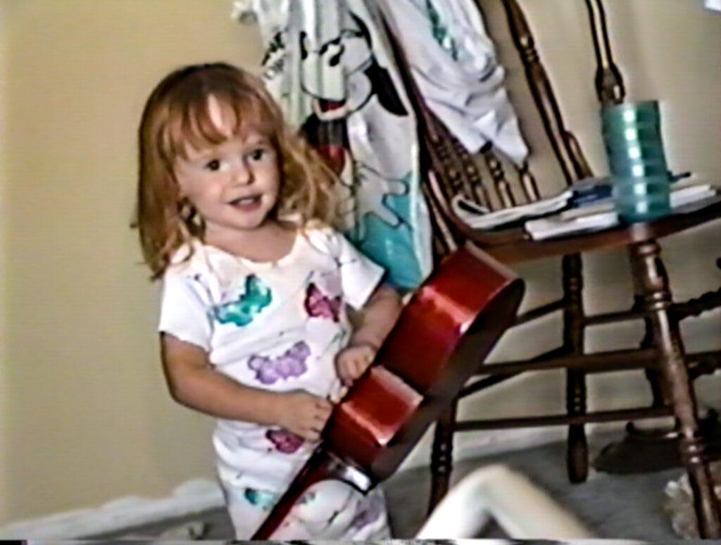 Pretending to sing and play guitar as a toddler