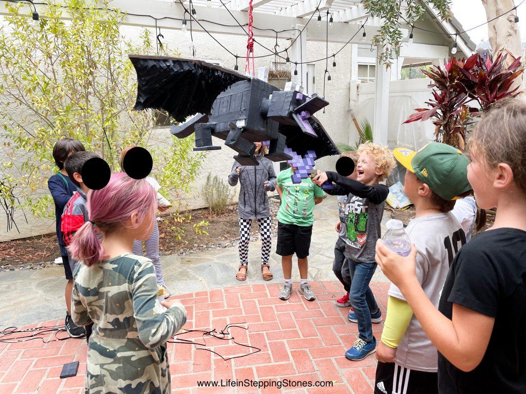 Minecraft birthday party activity involves fighting the Enderdragon piñata.