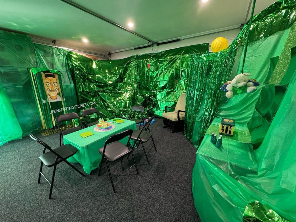 Wicked party decorations of the Emerald City with Wizard behind the curtain, animal in the cage, and a flying monkey